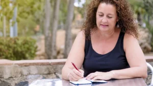 אישה כותבת במחברת בריכוז רב